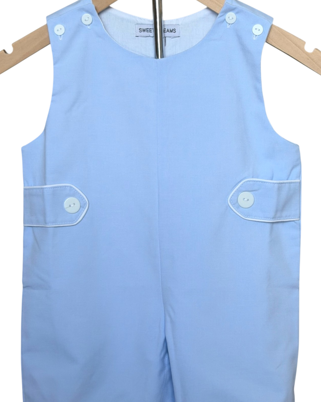 Light blue sleeveless romper with button details on a wooden hanger.
