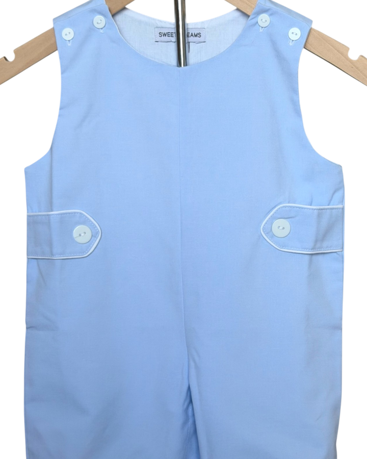 Light blue sleeveless romper with button details on a wooden hanger.
