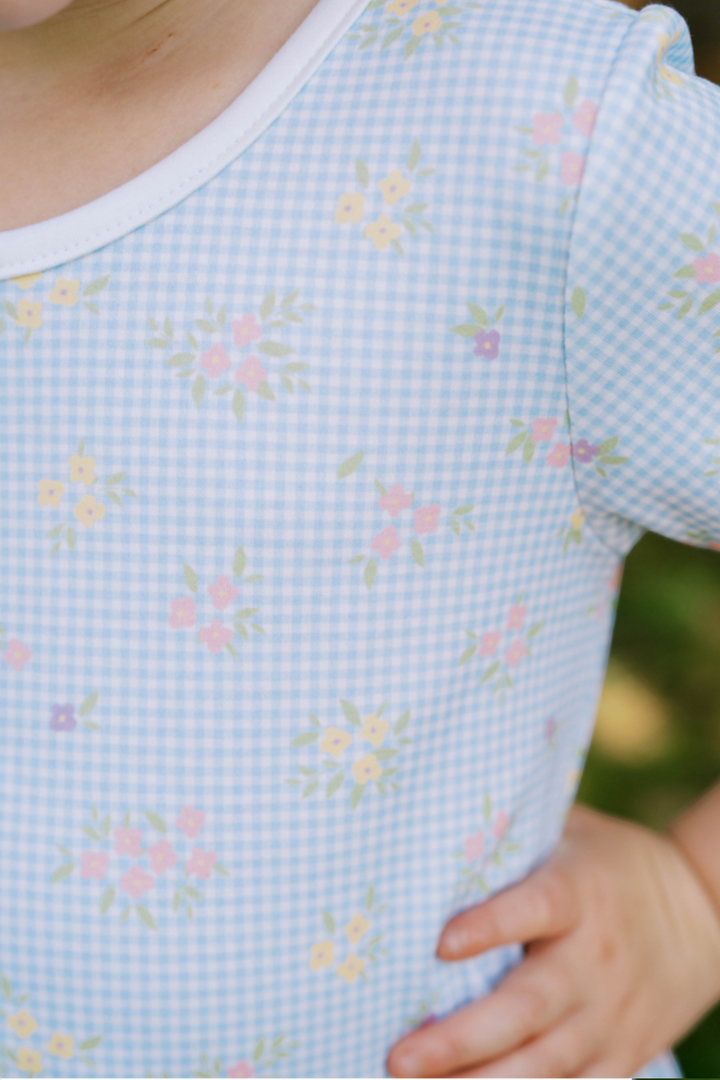 Light blue checkered shirt with floral pattern worn by a child