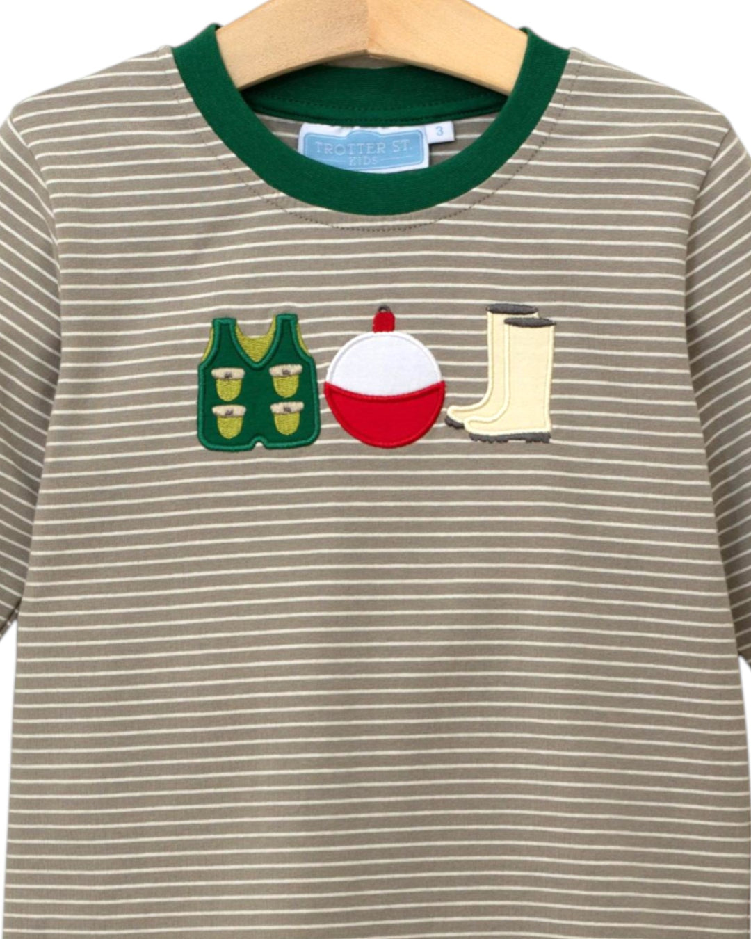Striped shirt with fishing-themed appliqués on a hanger