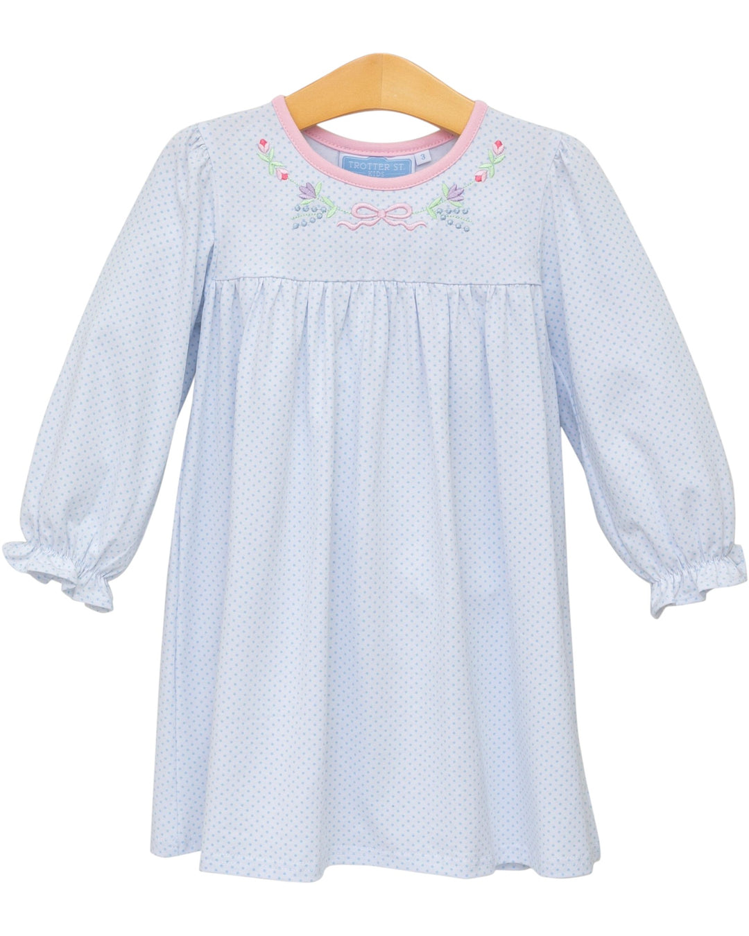 Light blue dress with floral embroidery on a wooden hanger against a white background