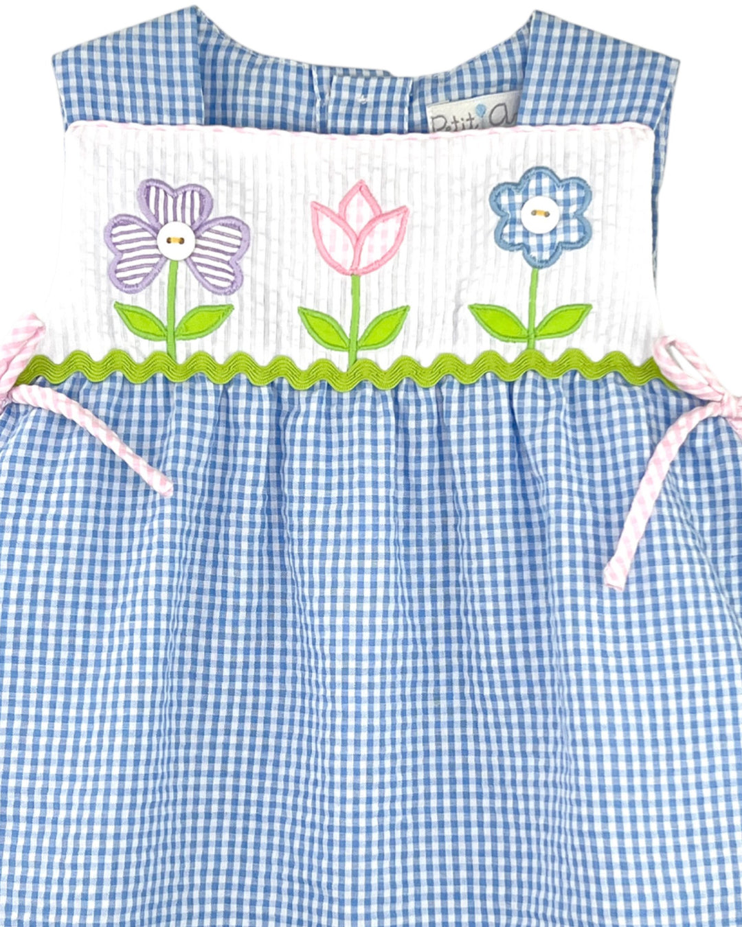 Children's dress with blue checkered top and floral skirt on a white background