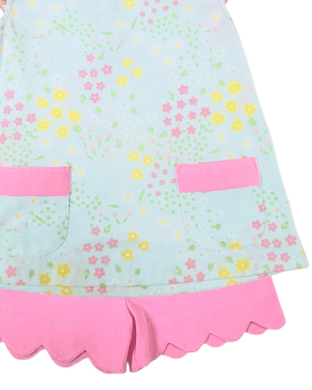 Children's dress with floral pattern and pink accents on a light blue background