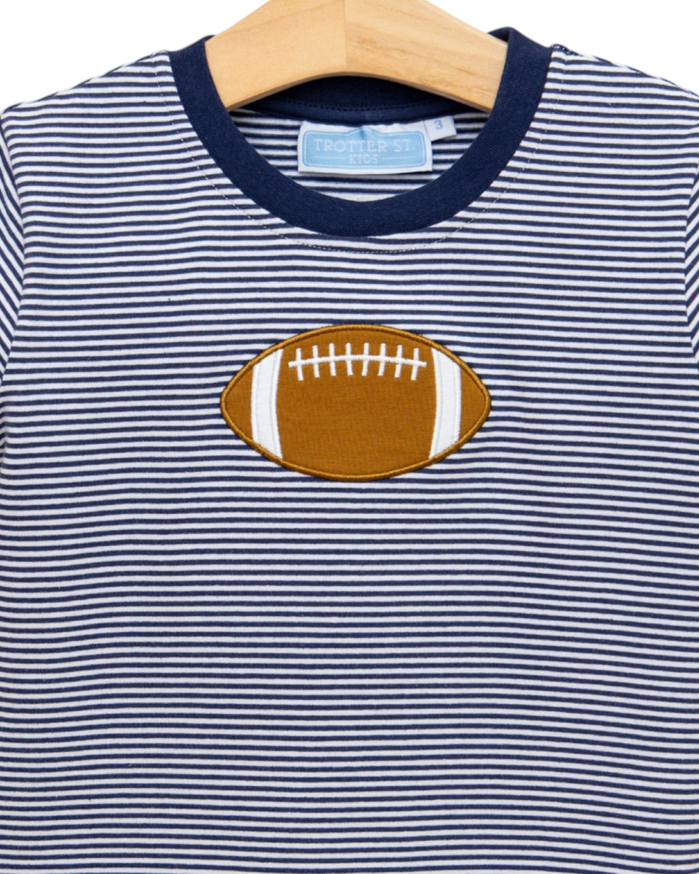 Navy and white striped shirt with a football patch on a hanger