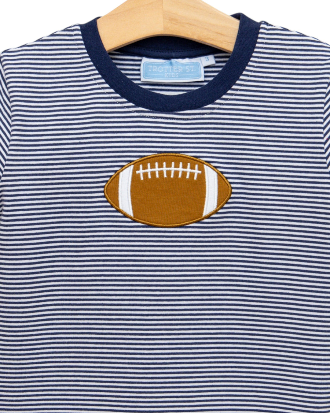 Navy and white striped shirt with a football patch on a hanger