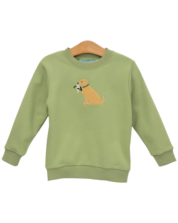 A sage green long-sleeve crewneck sweatshirt featuring an embroidered golden retriever dog holding a green leaf on the chest, displayed on a wooden hanger against a white background, that store