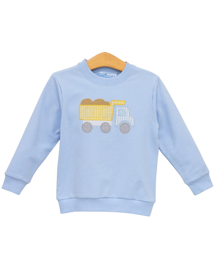 A light blue long-sleeve crewneck sweatshirt for toddlers, featuring a yellow and white checkered dump truck applique on the chest, displayed on a wooden hanger against a white background, that store