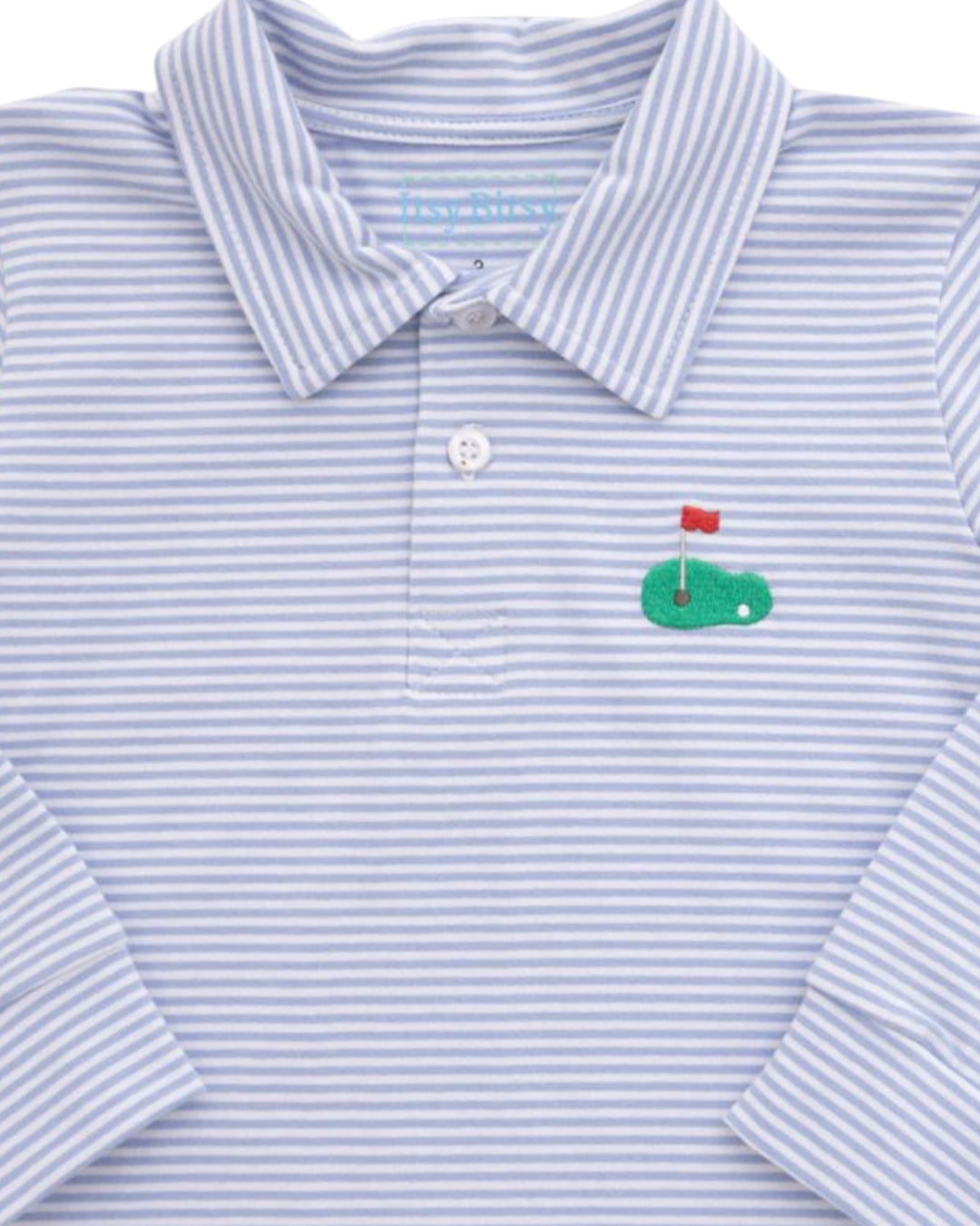 A close-up of a long-sleeve polo shirt with fine light blue and white horizontal stripes, featuring a small embroidered green golf hole graphic with a red flag on the left chest, that store