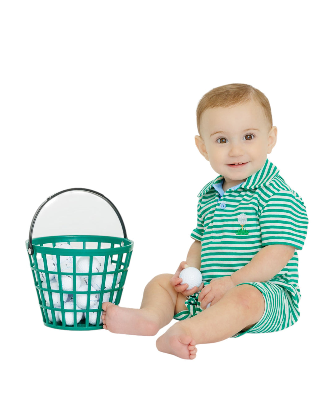 Baby in a green and white striped outfit with a basket of balls on a white background