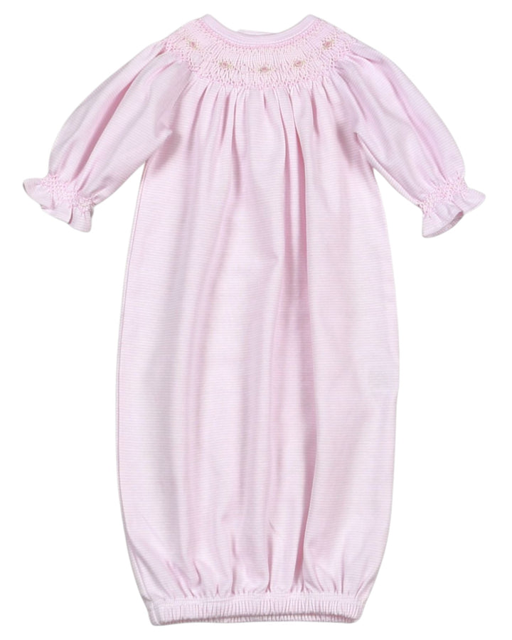 Pink baby gown with smocked details on a white background