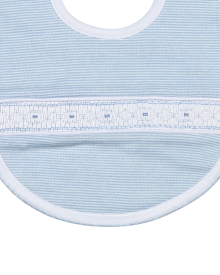 Close-up of a light blue baby bib with white trim on a white background