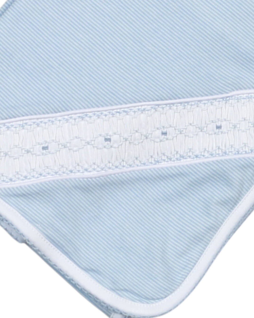 Close-up of a blue and white striped fabric with a textured border.