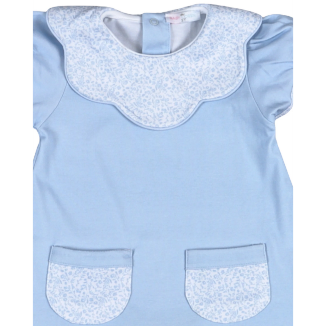 Light blue dress with white floral collar and pocket trim on a white background