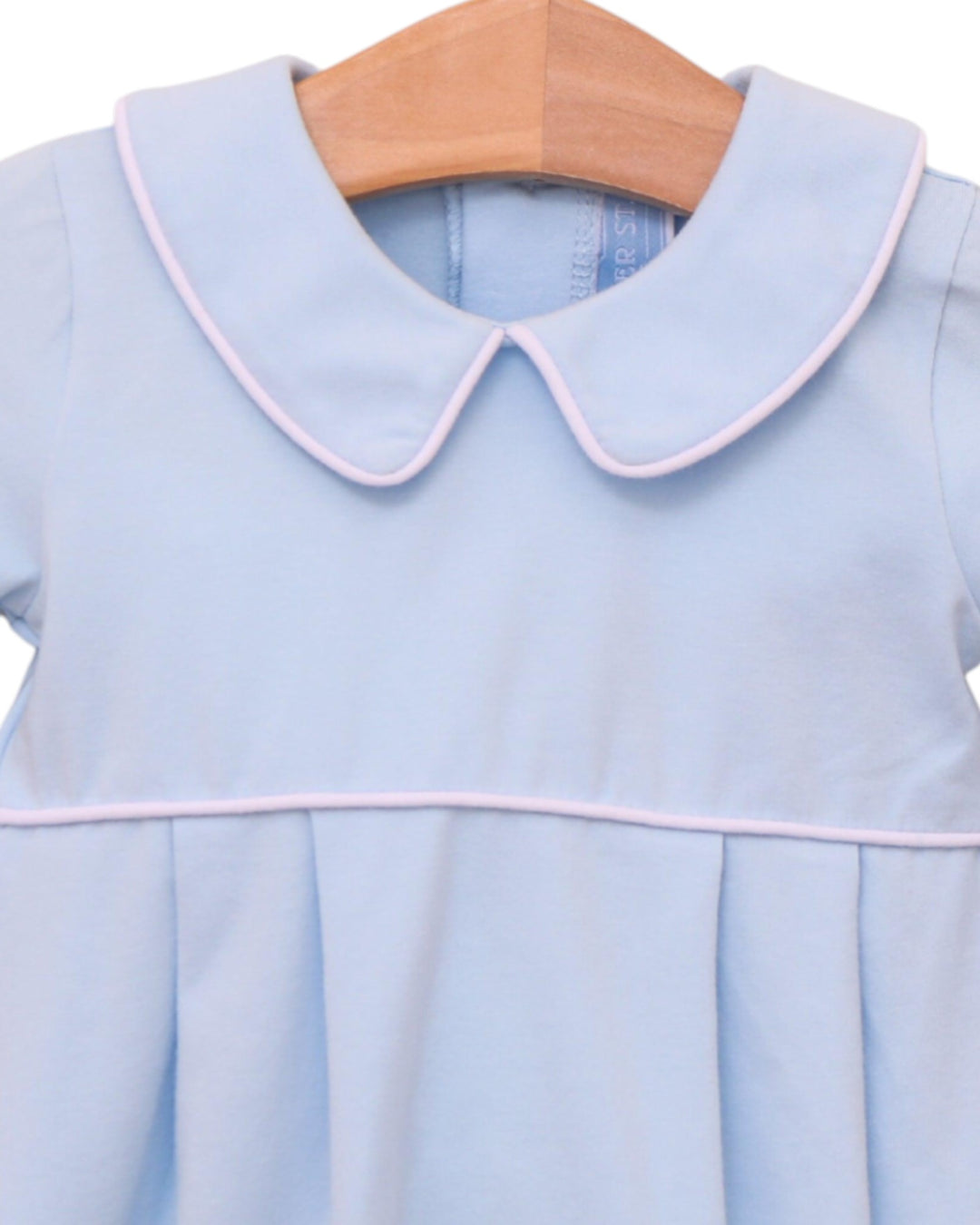 Light blue dress with pink trim on a wooden hanger