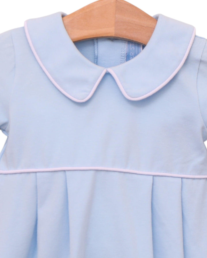 Light blue dress with pink trim on a wooden hanger