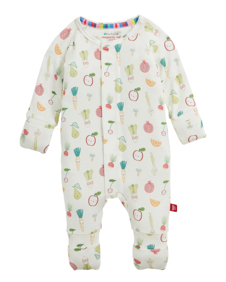 A baby long-sleeve footed sleeper in cream with a colorful vegetable print, featuring an asymmetrical snap closure and a small red tag on the leg, that store