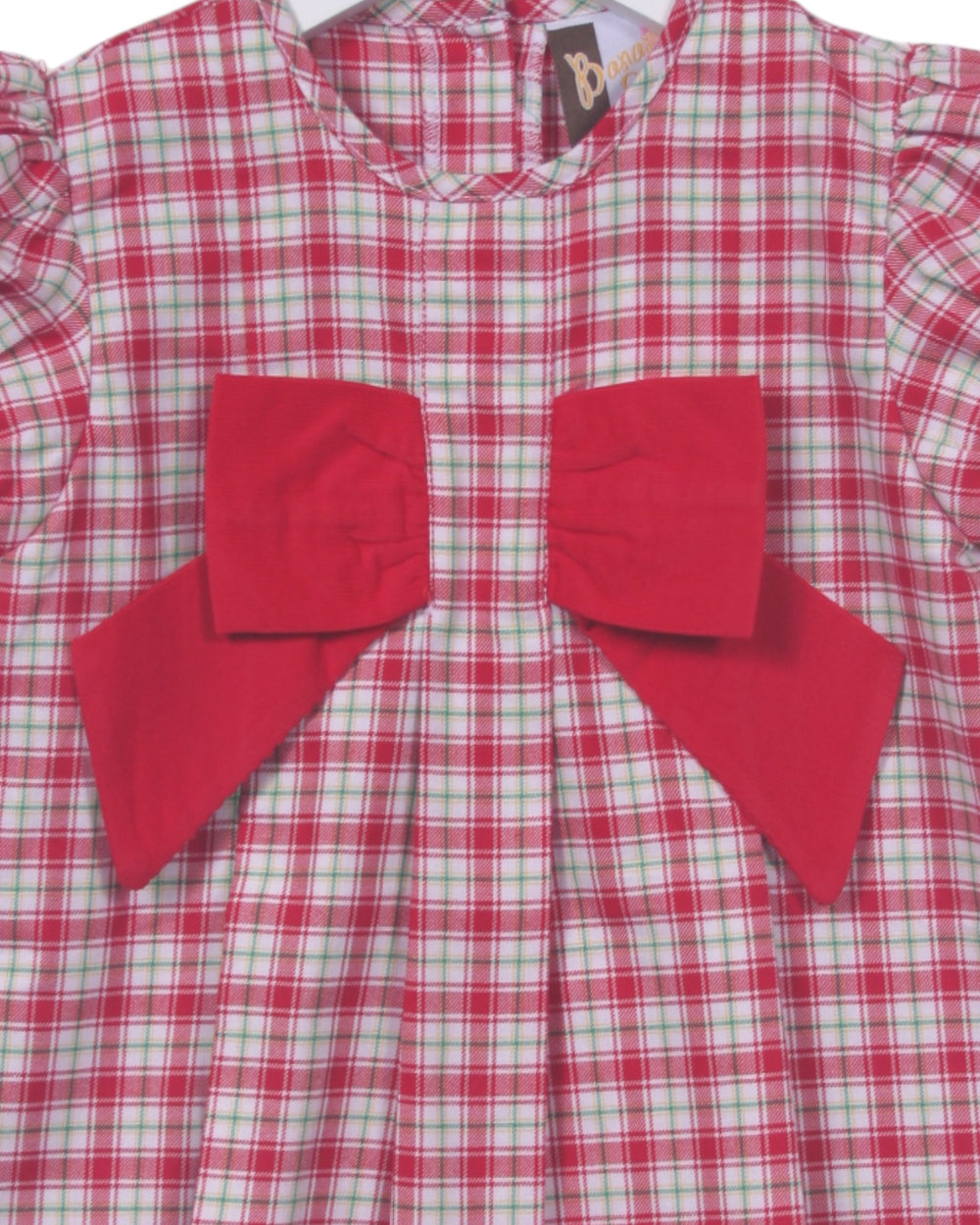 Red and green checkered dress with large red bows on a white background