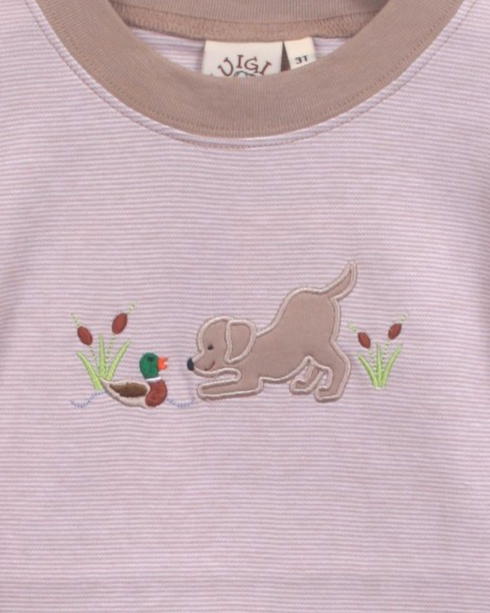 Close-up of a children's light pink ribbed knit top with a brown embroidered puppy and duck motif on the chest, featuring a beige crew neck, that store