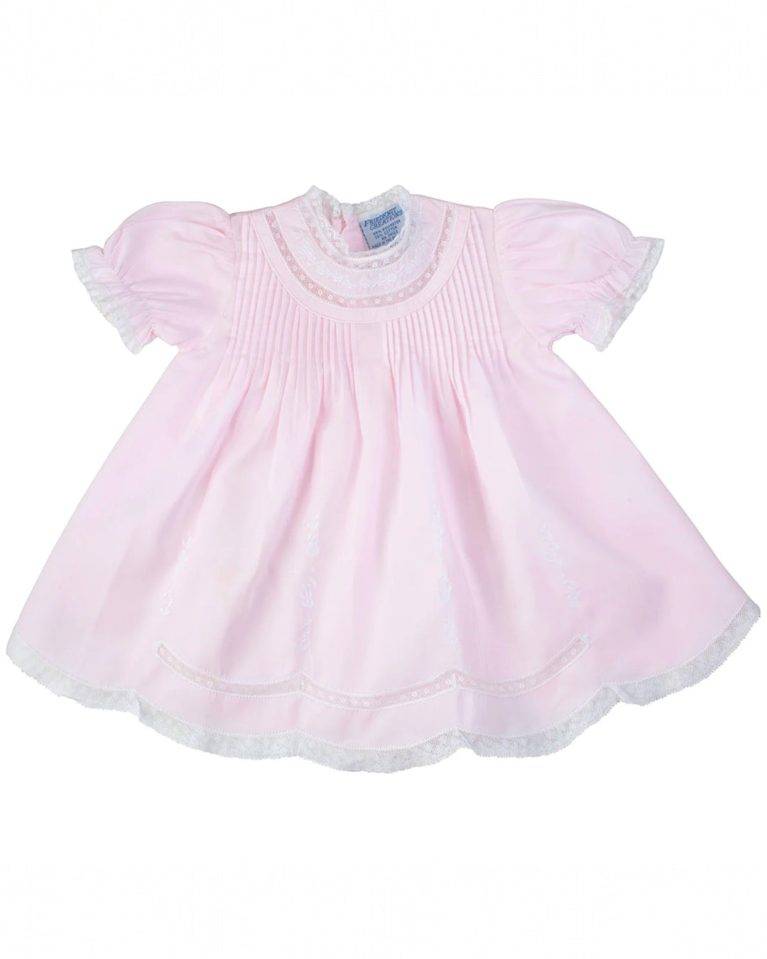 Pink baby dress with lace details on a white background
