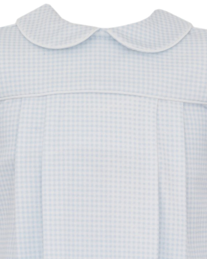 Close-up of a light blue and white gingham dress with a Peter Pan collar and front pleats, that store