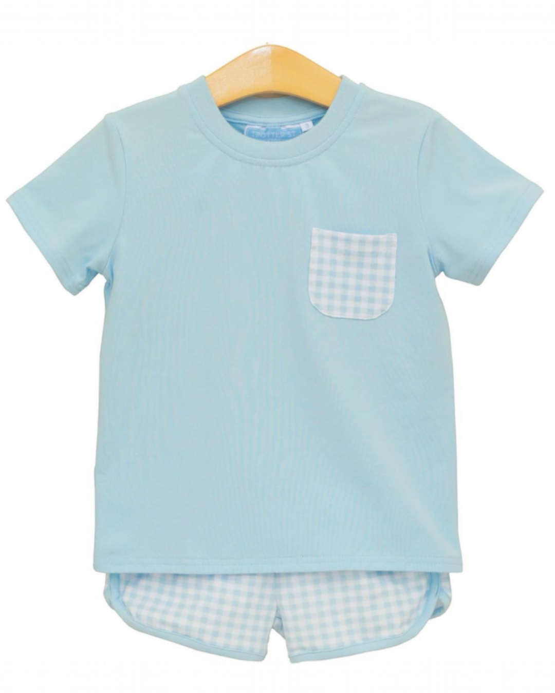 Light blue children's t-shirt with a pocket and matching shorts on a hanger against a white background