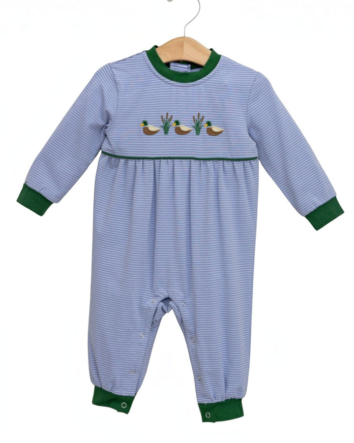 A baby long-sleeve footless romper in light blue and white stripes, featuring green ribbed cuffs and collar, a smocked waist, and embroidered ducks and cabbages on the chest, hanging on a wooden hanger against a white background, that store