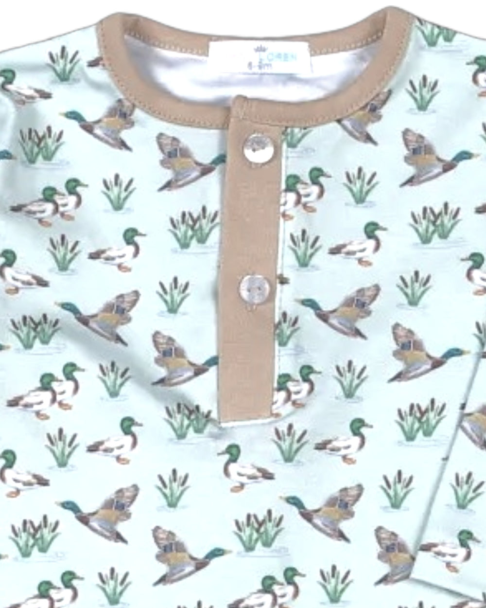 A close-up of a baby Henley shirt featuring a repeating pattern of mallards and reeds on a pale mint green background, with a tan collar and placket, that store
