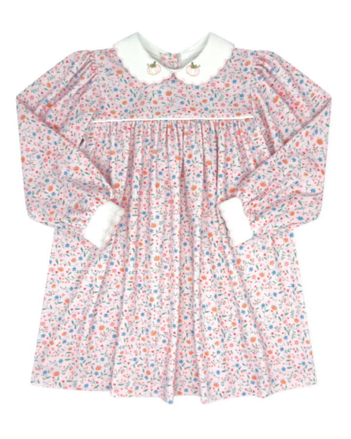 A long-sleeve baby dress with a delicate pink, blue, and orange floral print on a white background, featuring a white Peter Pan collar with gold buttons and white cuffs, that store