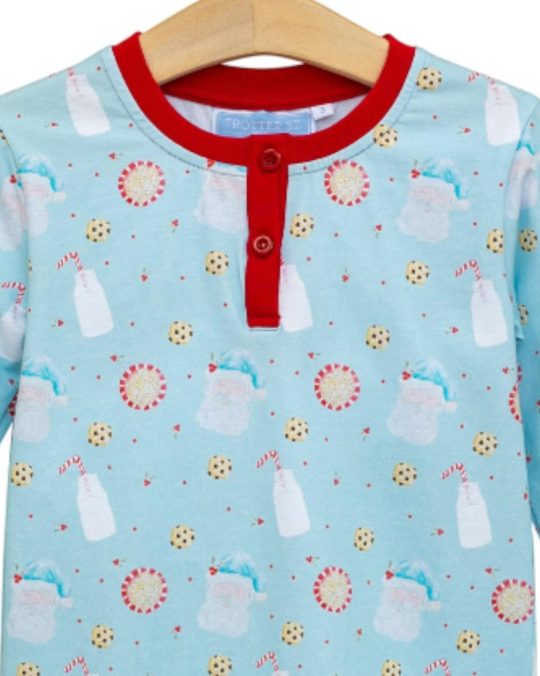Children's pajama top with milk bottle and flower pattern on a hanger