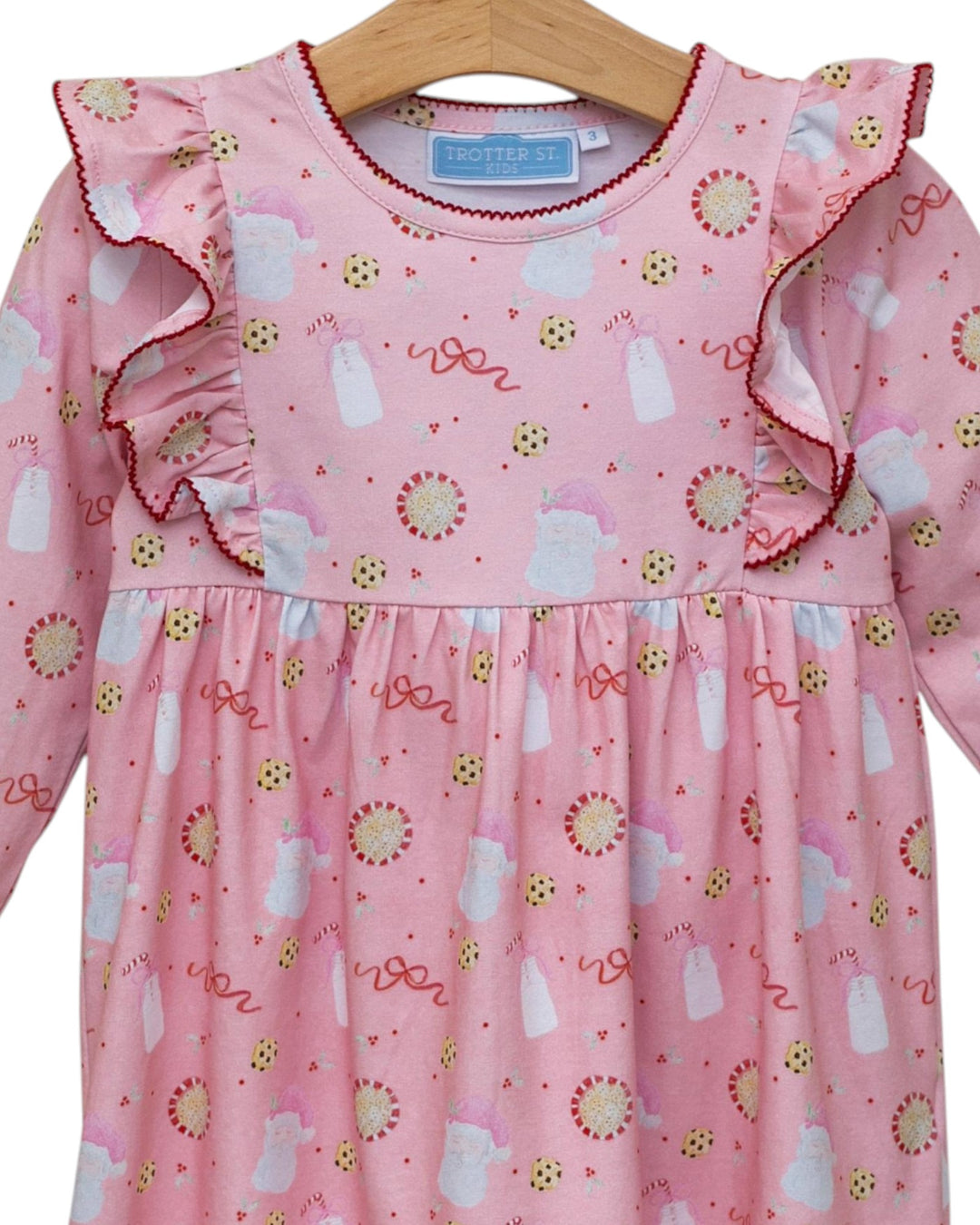 Pink dress with ruffled collar and pattern on a hanger