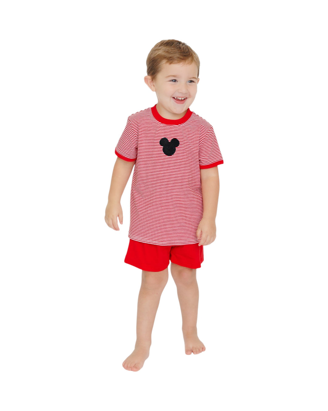 Child wearing a red and white striped shirt with a black heart and red shorts on a white background