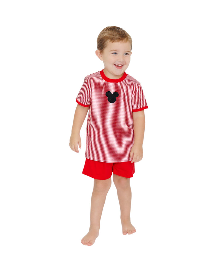 Child wearing a red and white striped shirt with a black heart and red shorts on a white background