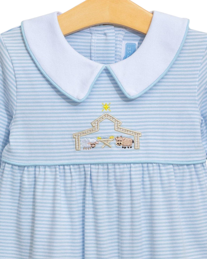 Light blue dress with embroidered design on a wooden hanger