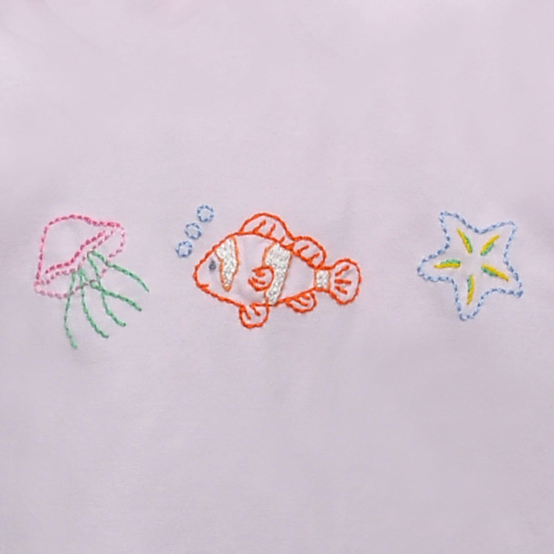 Embroidered design of a fish, squid, and starfish on a light background