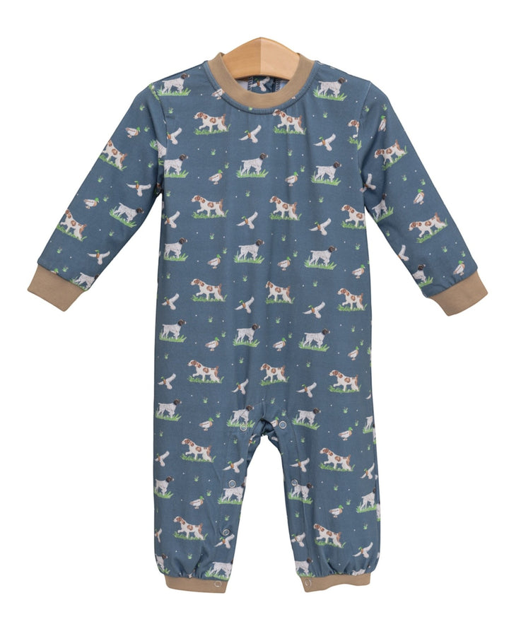 A baby long-sleeve footless one-piece romper in slate blue, featuring an all-over print of dogs and cats in a grassy field, with tan ribbed cuffs and collar, hanging on a wooden hanger against a white background, that store
