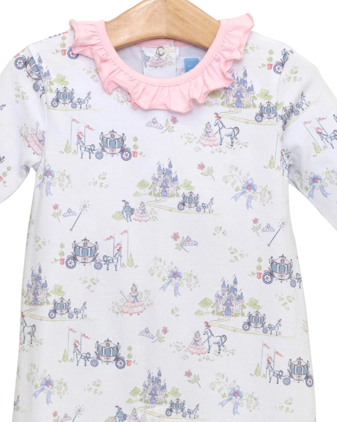 Children's dress with fairy tale carriage print and pink ruffled collar on a hanger.