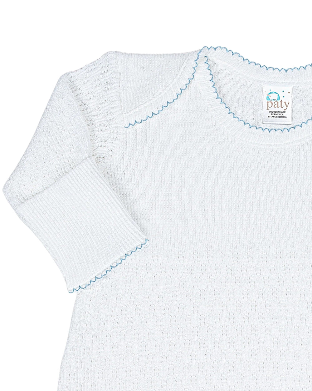 White baby dress with blue trim on a white background