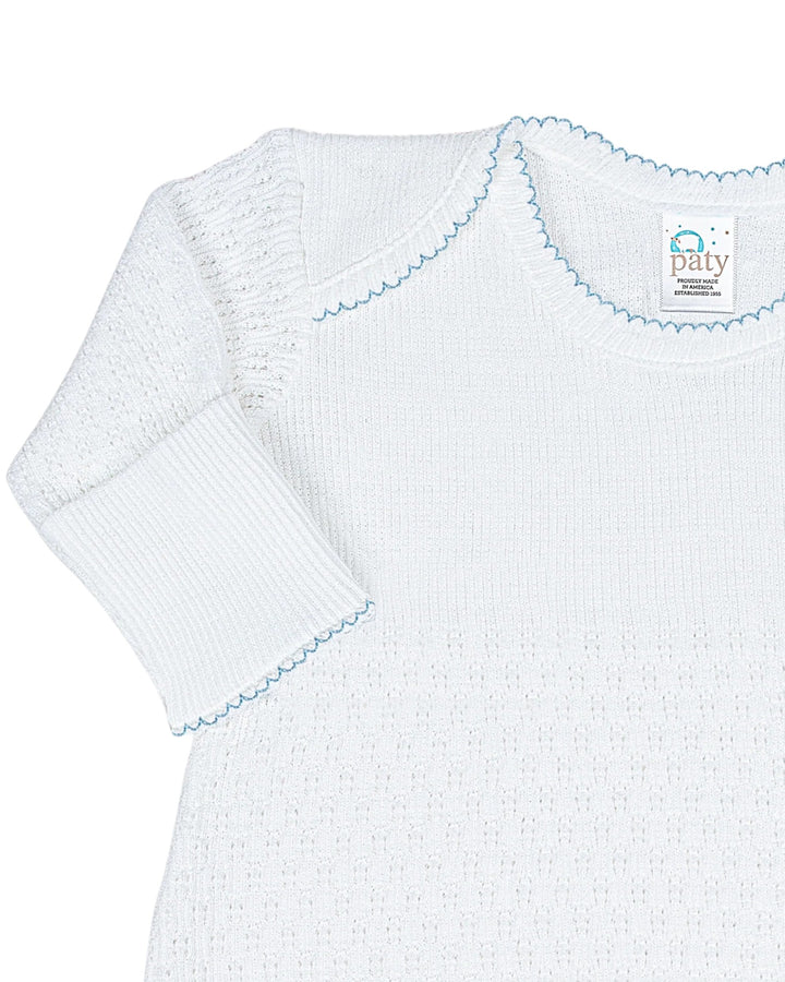 White baby dress with blue trim on a white background