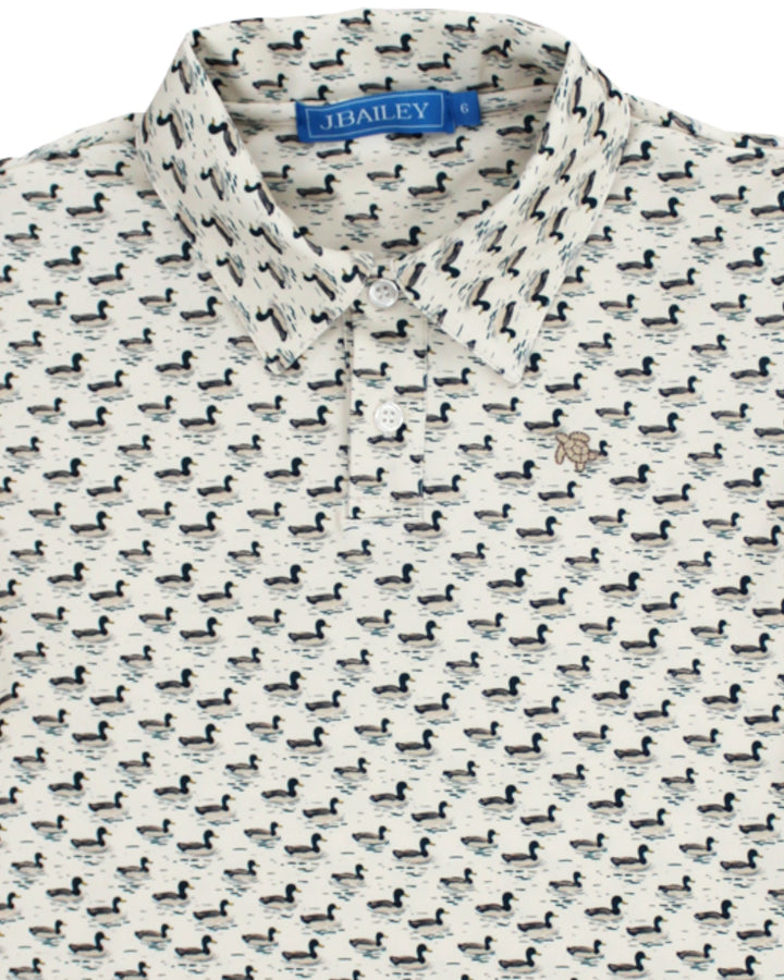 A close-up of a J.Bailey short-sleeve button-up shirt featuring an all-over black duck print on a warm off-white background, that store