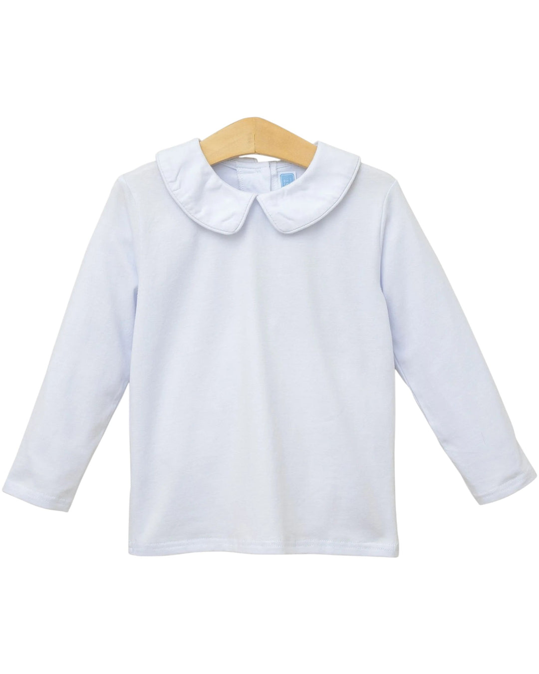 A white long-sleeve baby top with a Peter Pan collar, displayed on a wooden hanger against a plain white background, that store