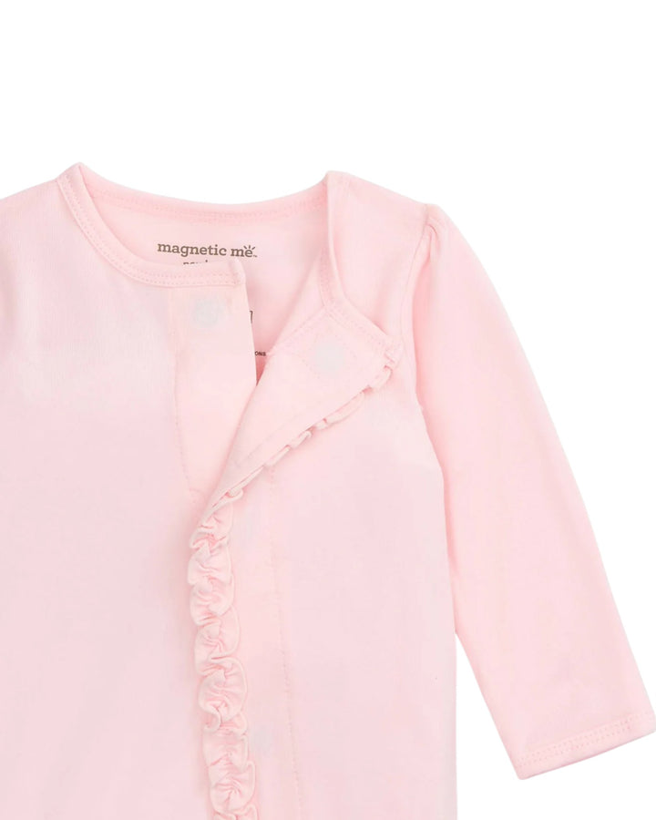 Pink baby cardigan with ruffled details on a white background