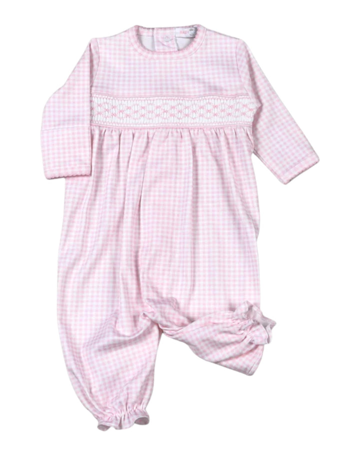A baby long-sleeve footless smocked jumpsuit in a light pink and white gingham pattern, featuring a decorative smocked chest panel and gathered leg cuffs, that store