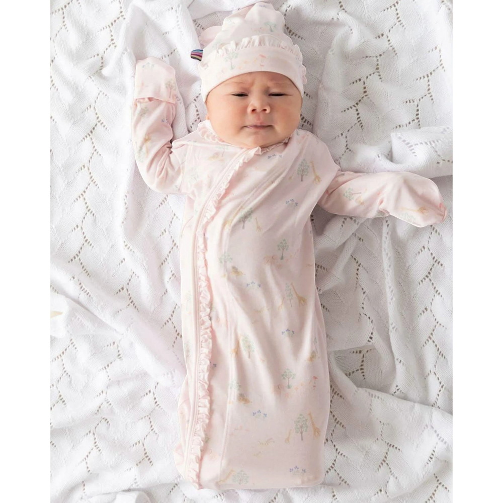 Baby wrapped in a pink swaddle with a matching hat on a white textured blanket