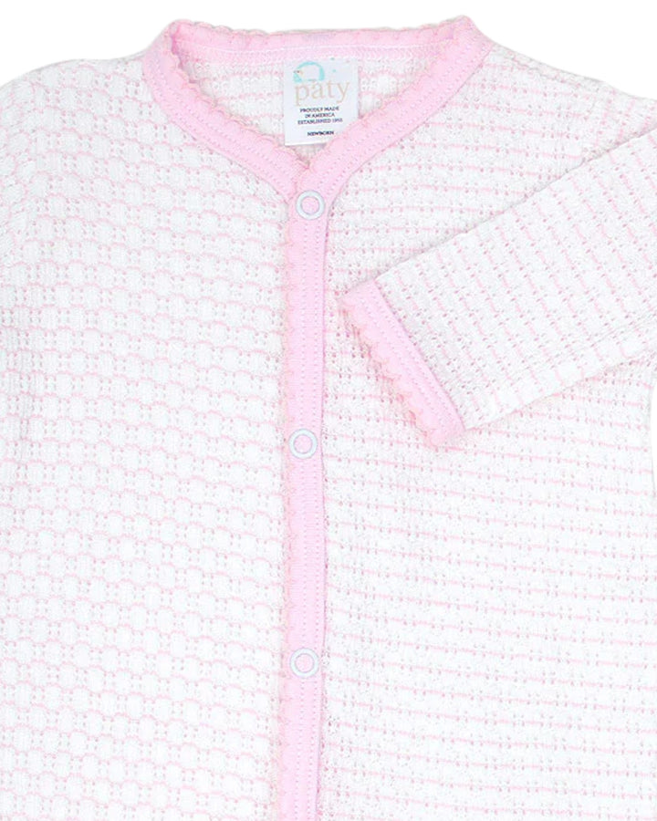 Baby cardigan with pink trim on a white background