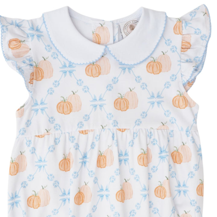 A white baby dress with a Peter Pan collar, ruffled sleeves, and an all-over print of orange pumpkins and light blue floral motifs, that store