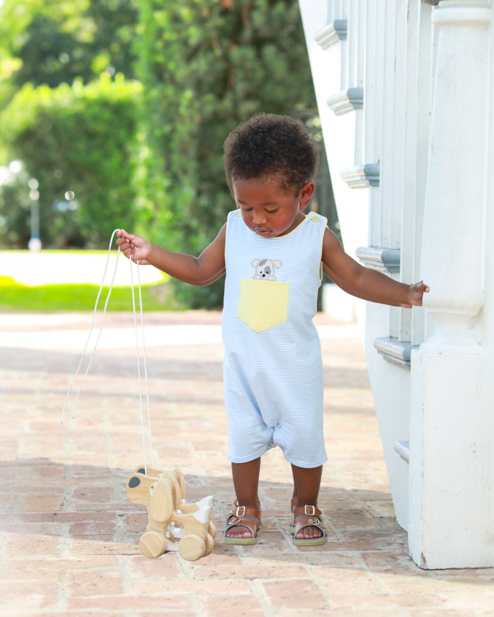 Child playing with a toy on a wooden deck