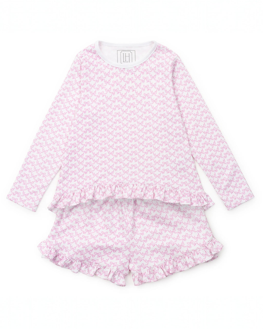 Pink pajama set with ruffle details on a white background