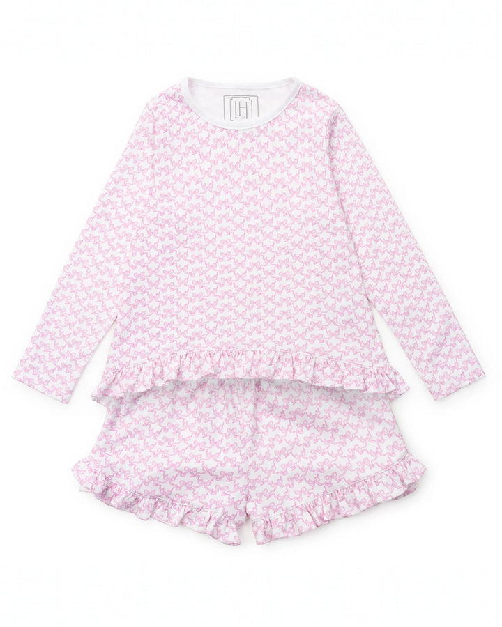 Pink pajama set with ruffle details on a white background