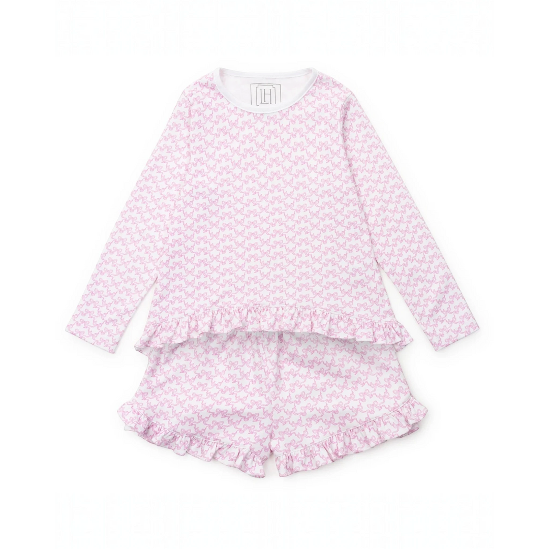 Pink pajama set with ruffle details on a white background