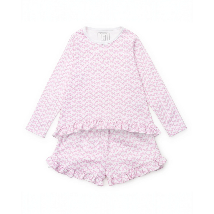 Pink pajama set with ruffle details on a white background